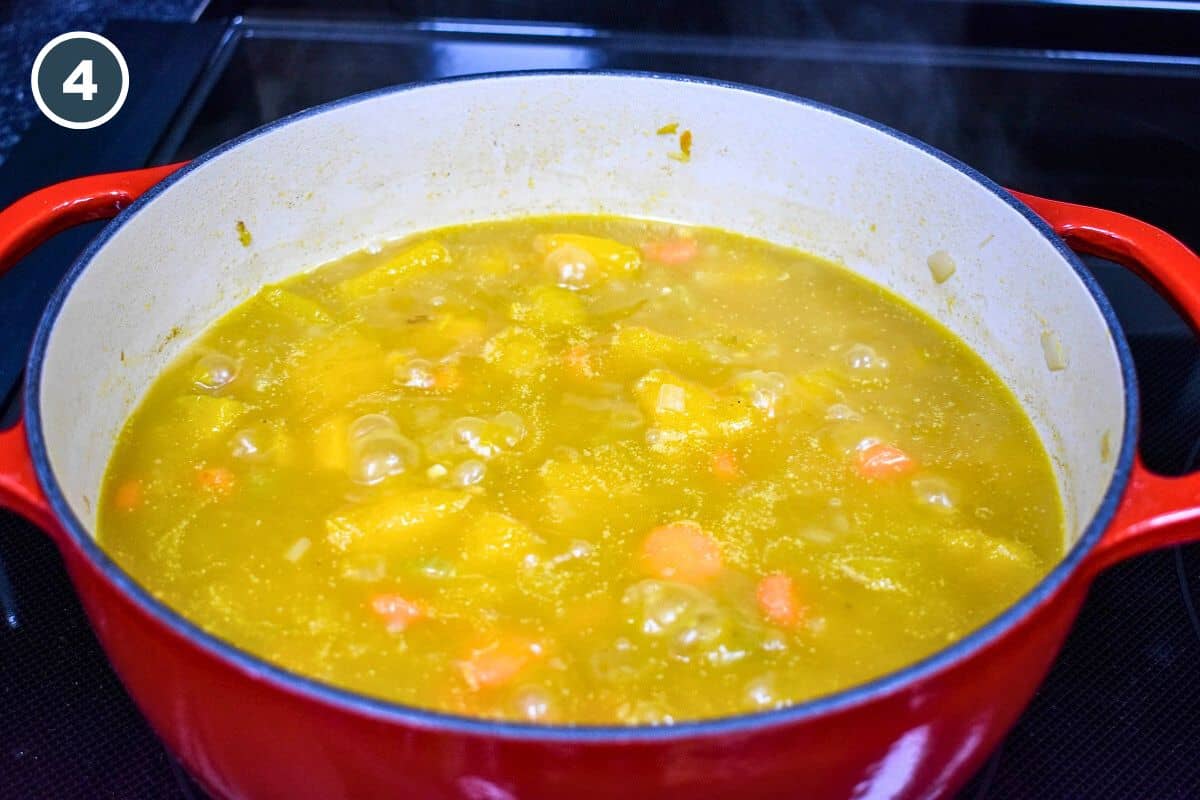 The soup simmering in a large pot.