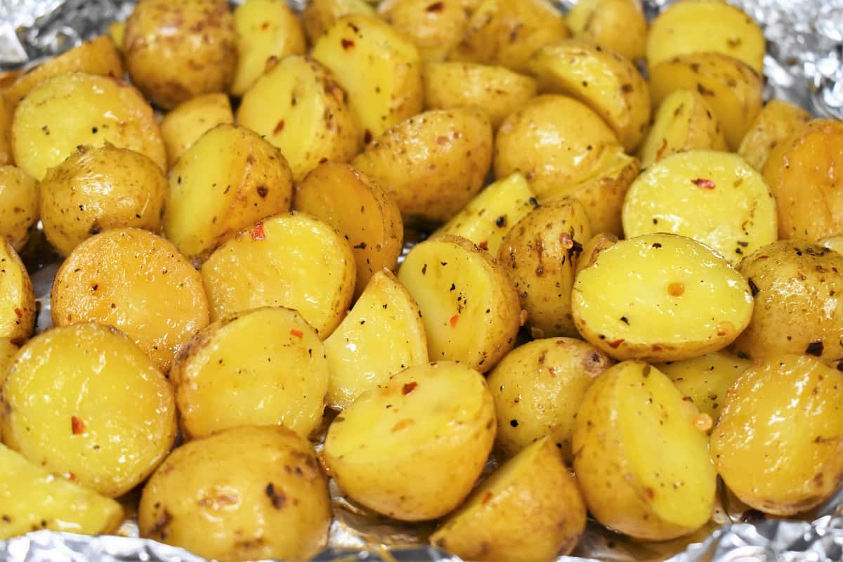 A close up picture of grilled potatoes in an open foil pack.