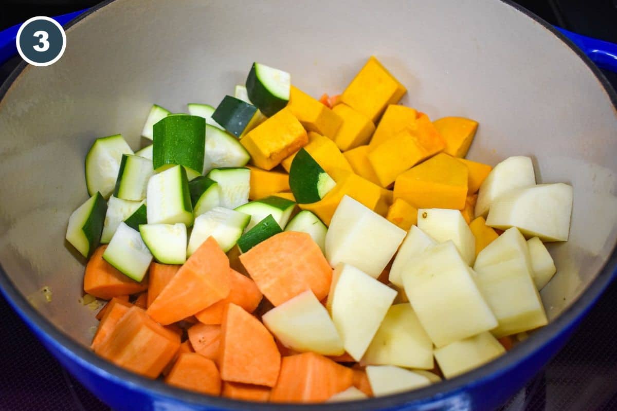 Cut pumpkin, potatoes, sweet potatoes, and zucchini added to a large pot.