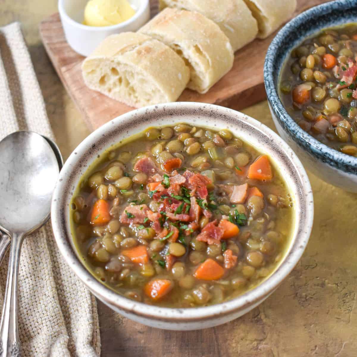 The finished soup served in small bowls, garnished with bacon bits and chopped parsley and served with bread and butter.