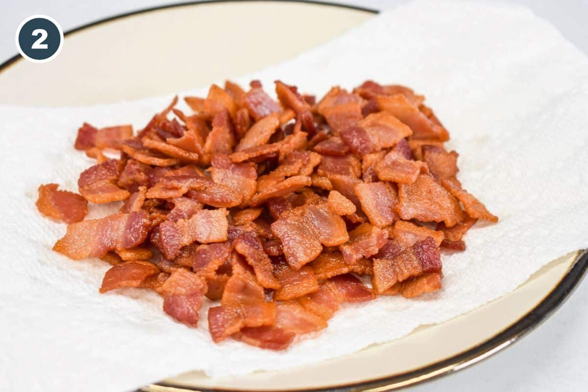 Bacon pieces cooked crispy and set on a plate lined with a white paper towel.