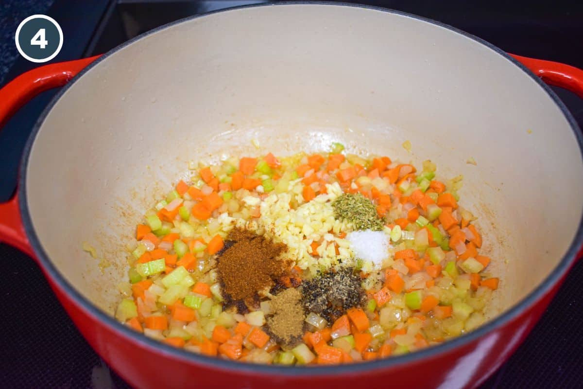 Minced garlic and spices added to the sauteed onions, carrots, and celery in the pot.