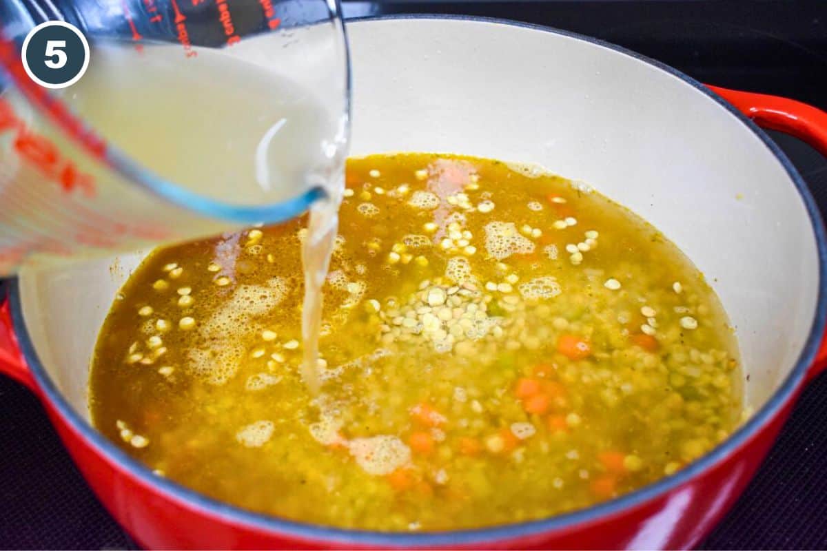 Chicken broth being added to the ingredients in the pot.