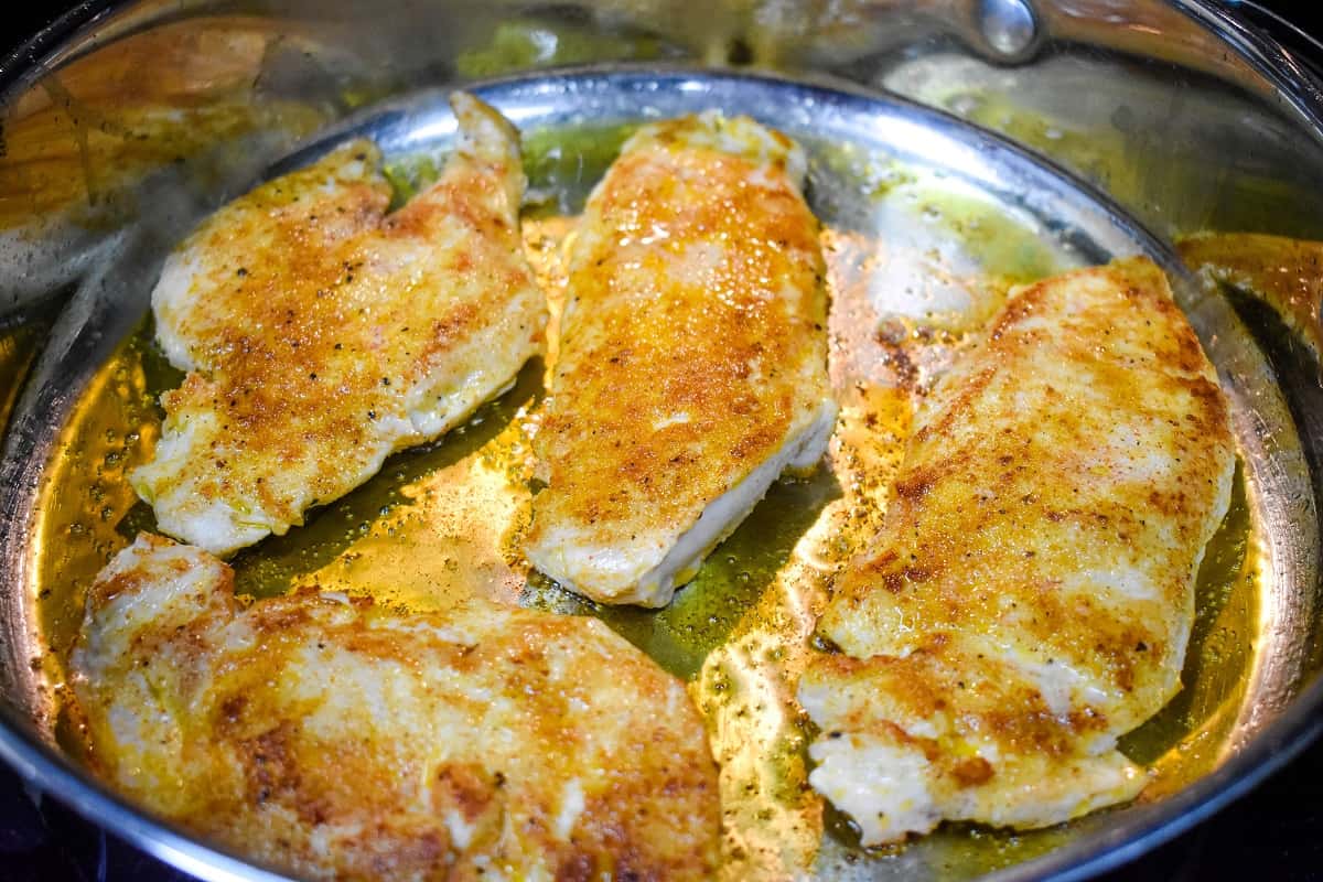 Cooked thin chicken breasts in a large skillet.