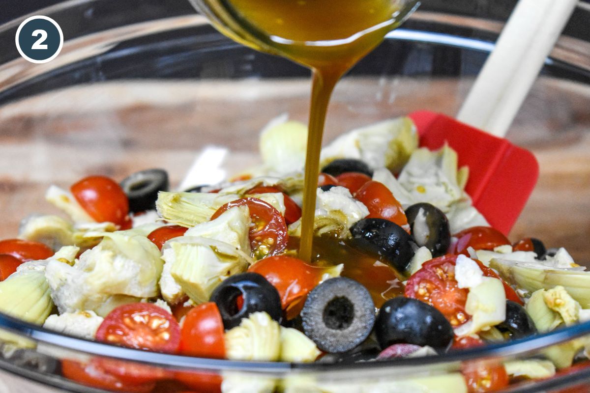 The salad dressing being streamed on the artichoke salad.