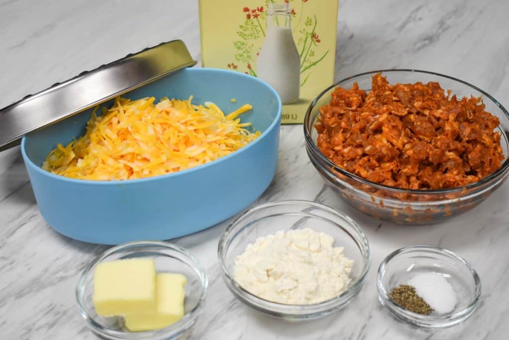 The ingredients for the chroizo cheese dip arranged on a white table.