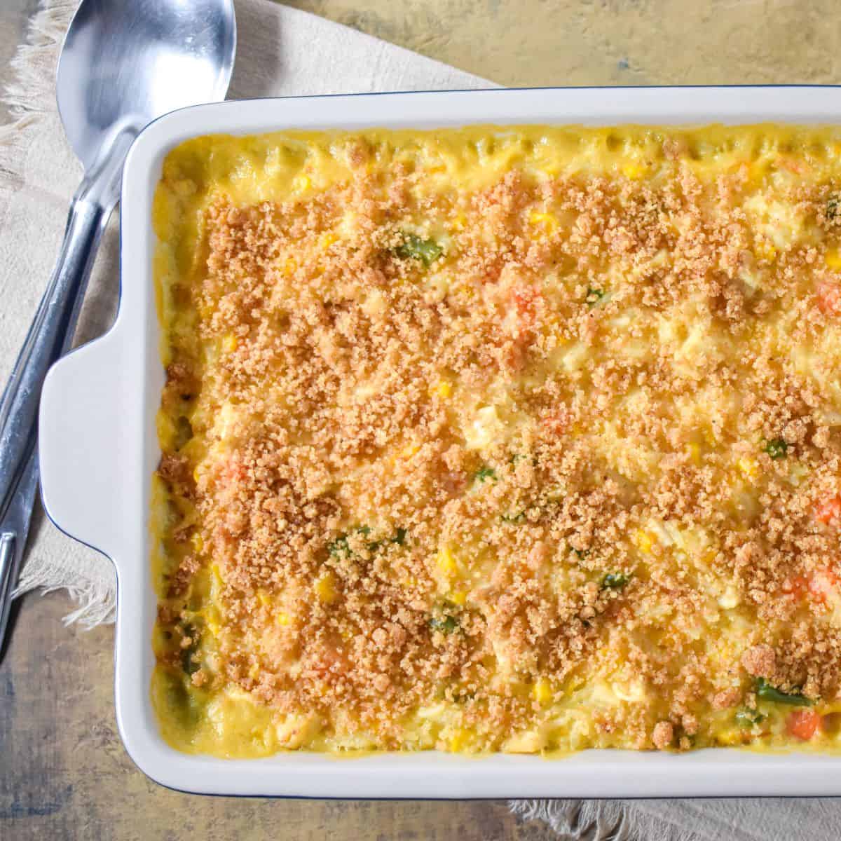 Creamy chicken and rice casserole in a white baking dish with a golden breadcrumb topping.