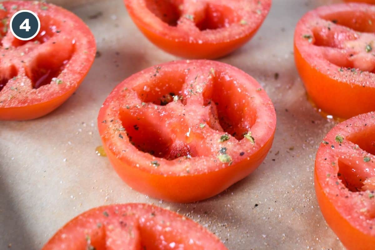 A few tomato halves set on a parchment sheet lined baking sheet.