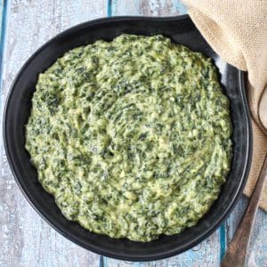 The creamed spinach served in a black skillet.