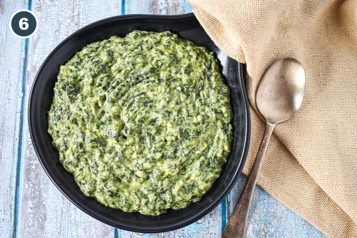 The finished creamy spinach side dish in a serving skillet.