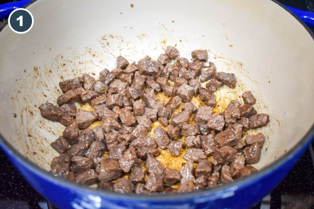 Small beef pieces browning in a large pot.