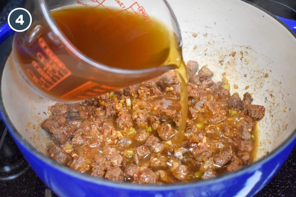 Beef broth being added to the ingredients in the pot.