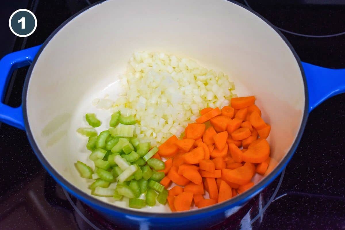 Onions, carrots, and celery added to a pot.