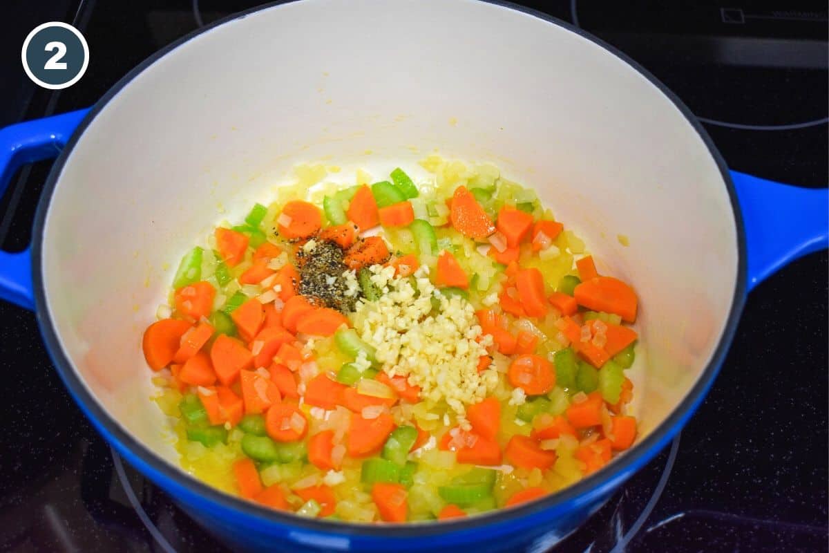 Minced garlic and pepper added to the vegetables cooking in the pot.