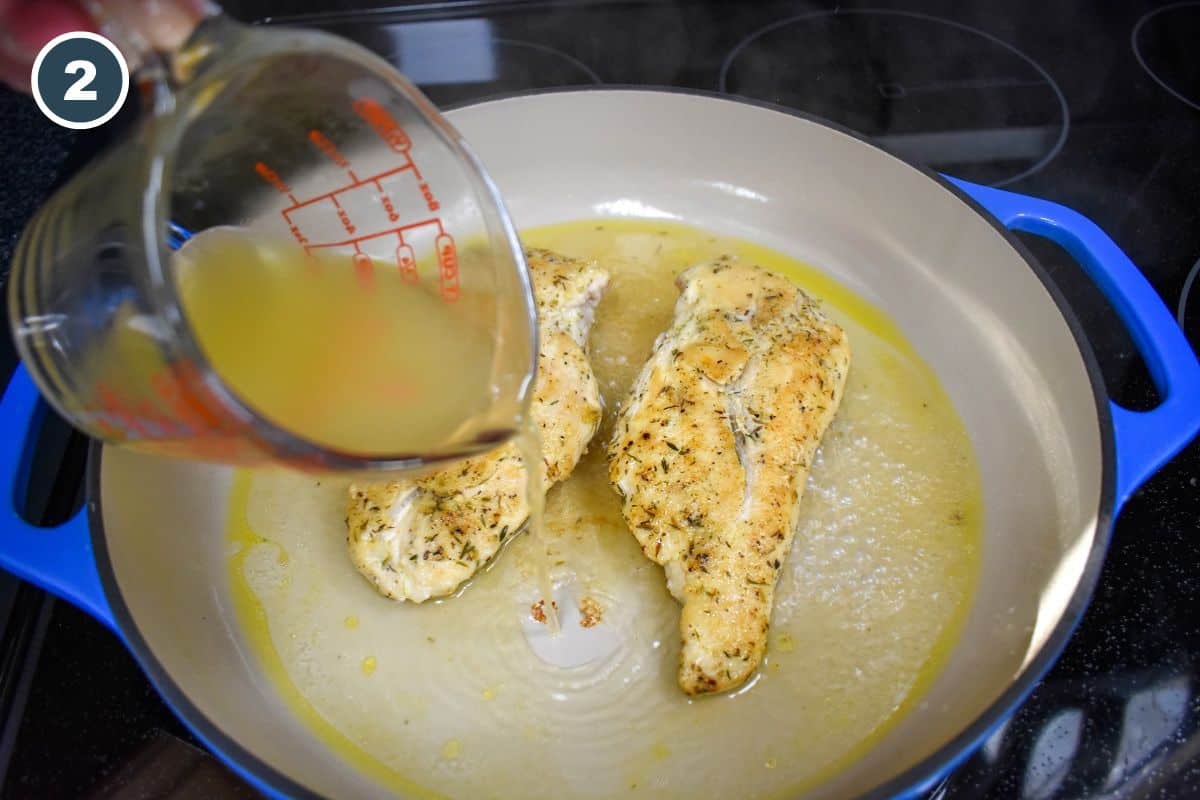 Chicken broth being added to the skillet with two pieces of chicken breast.