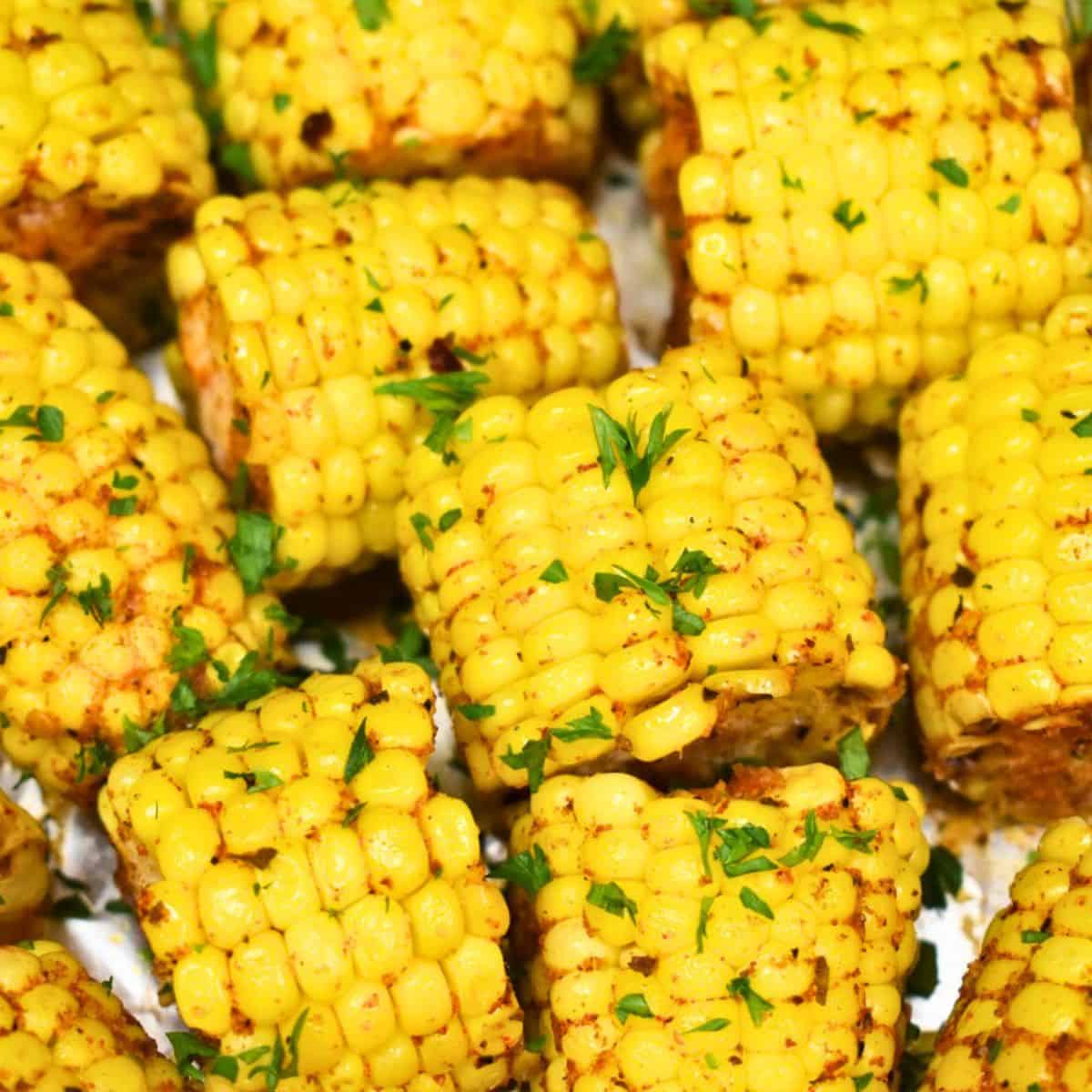 Cut corn cobs, seasoned and garnished with chopped parsley.