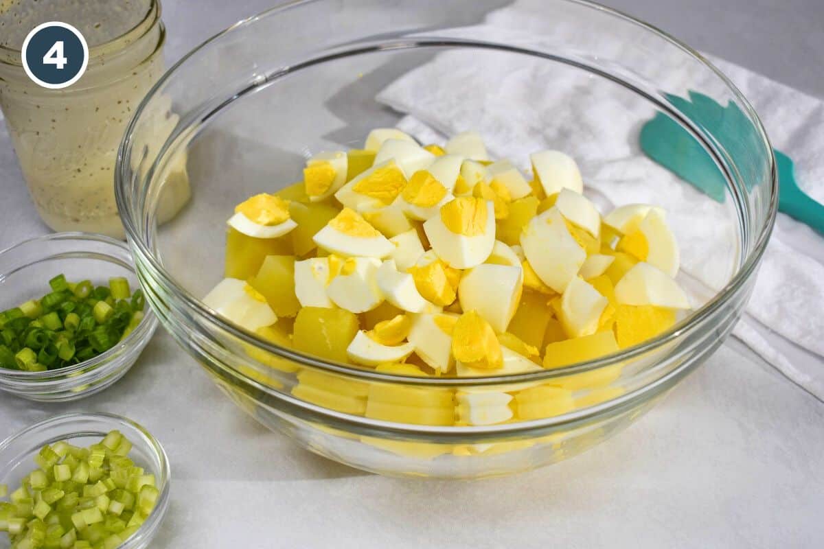 The cut potatoes and egg in a large, glass bowl.