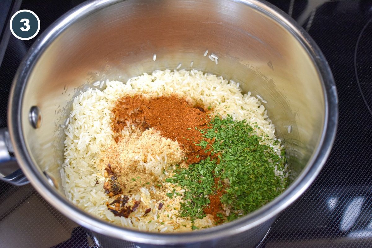 White rice, paprika, dried parsley, garlic powder and other seasoning in a saucepan.