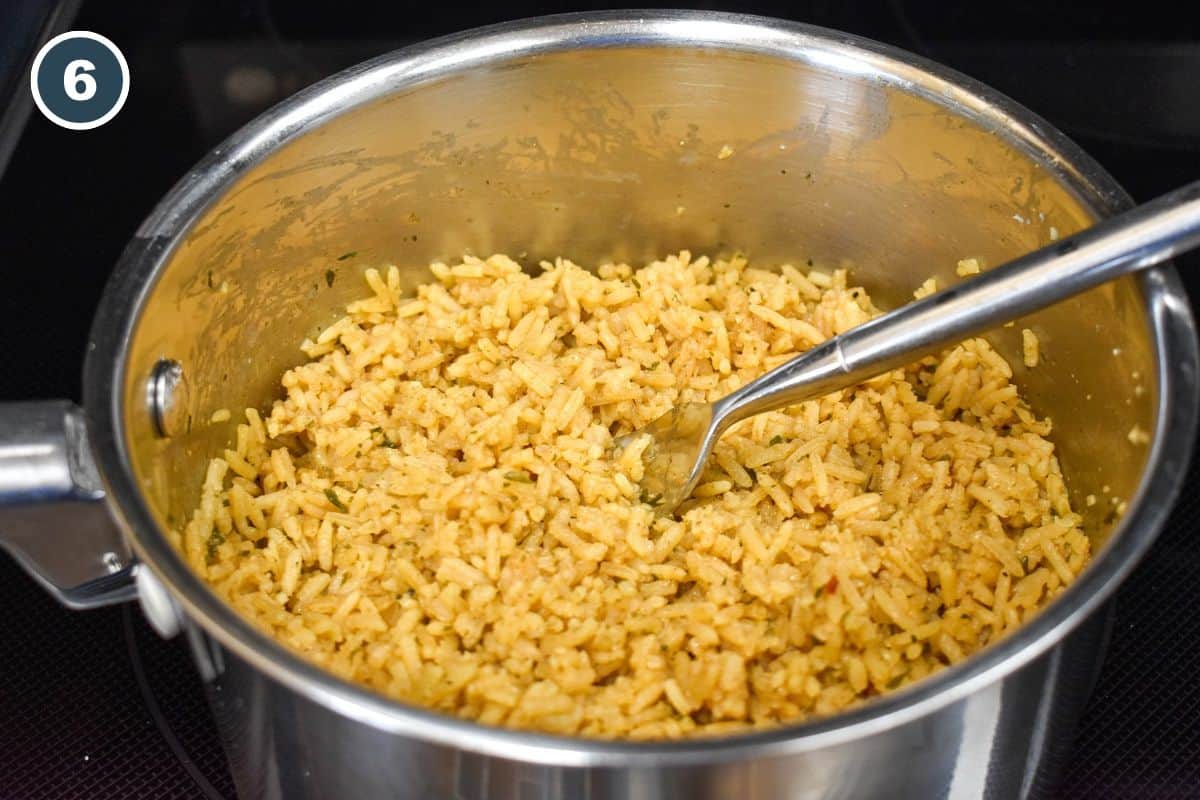 The finished rice still in the saucepan with a fork in it.