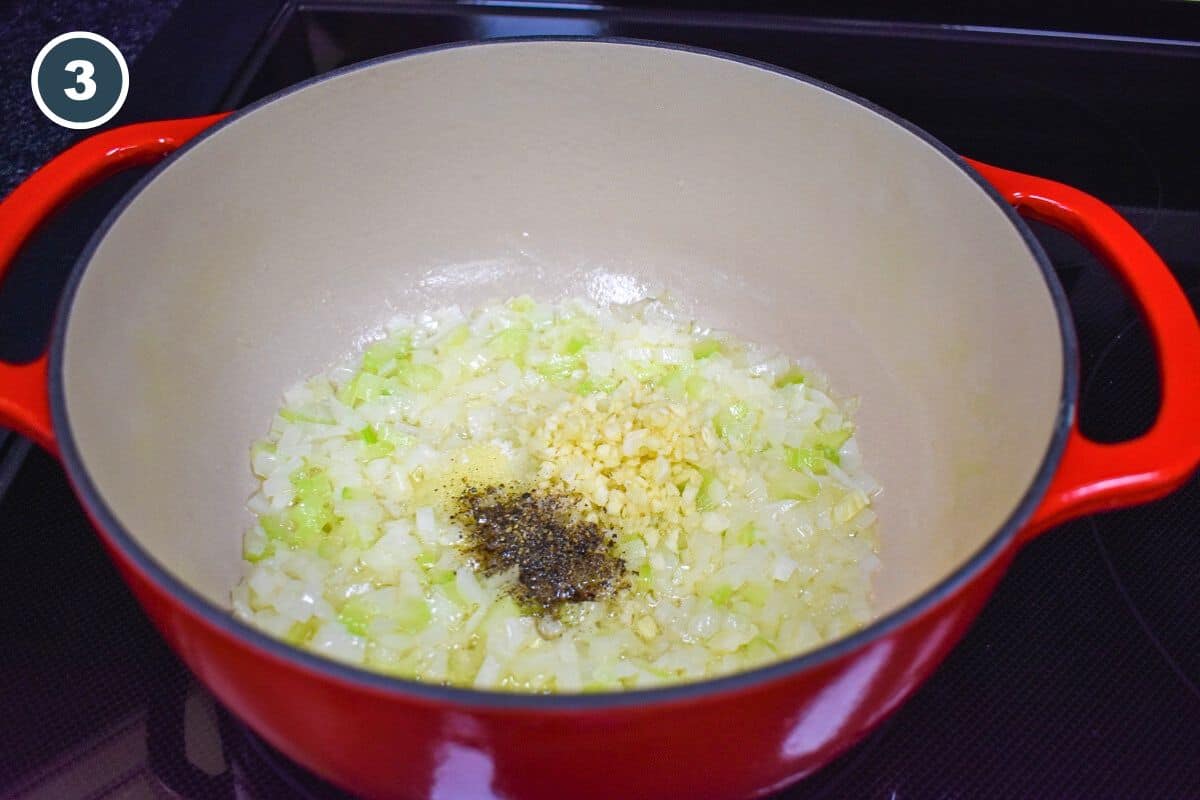 Minced garlic and black pepper added to diced onions and celery sautéing in a pot.