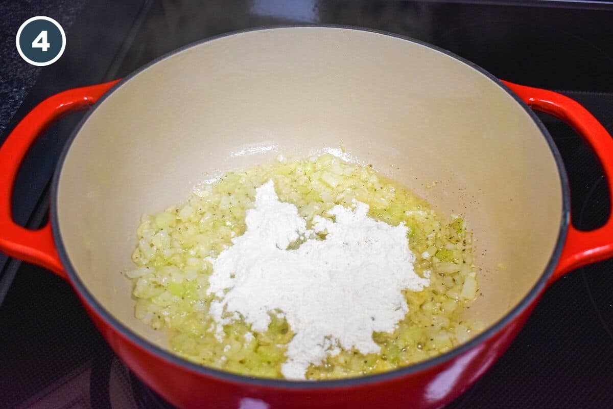 Flour added to the onions, celery, garlic, and spices cooking in a pot.