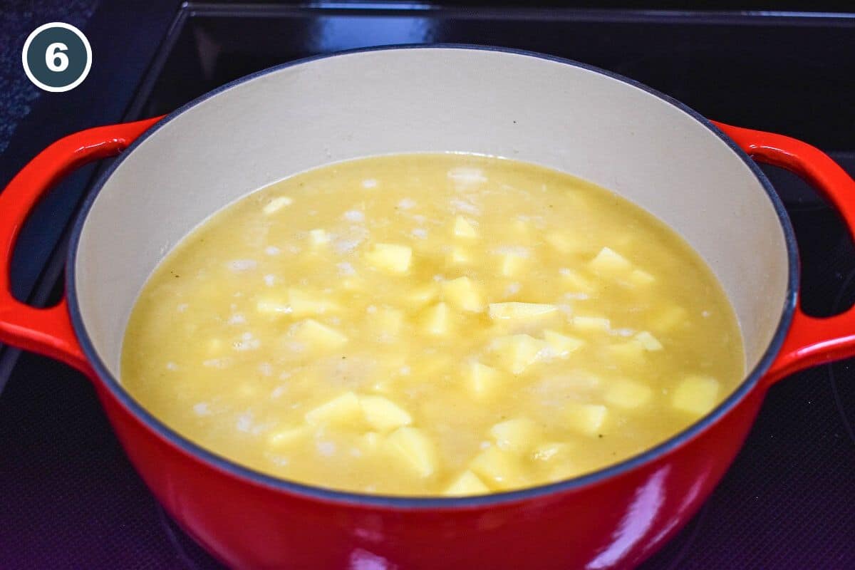 Diced potatoes added to the chicken broth in the pot.