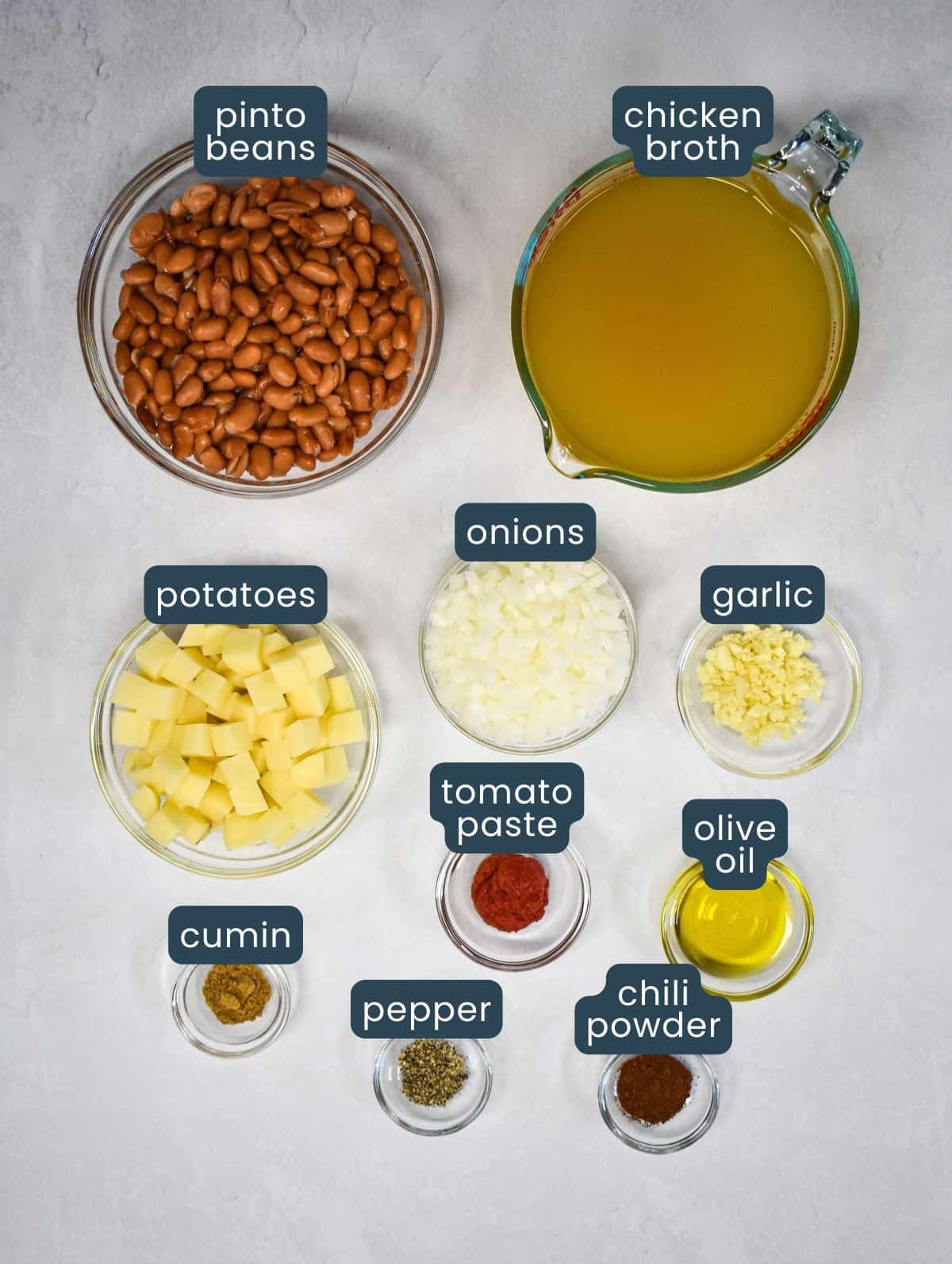 The ingredients for the recipe prepped and arranged in glass bowls with each labeled in blue and white letters.