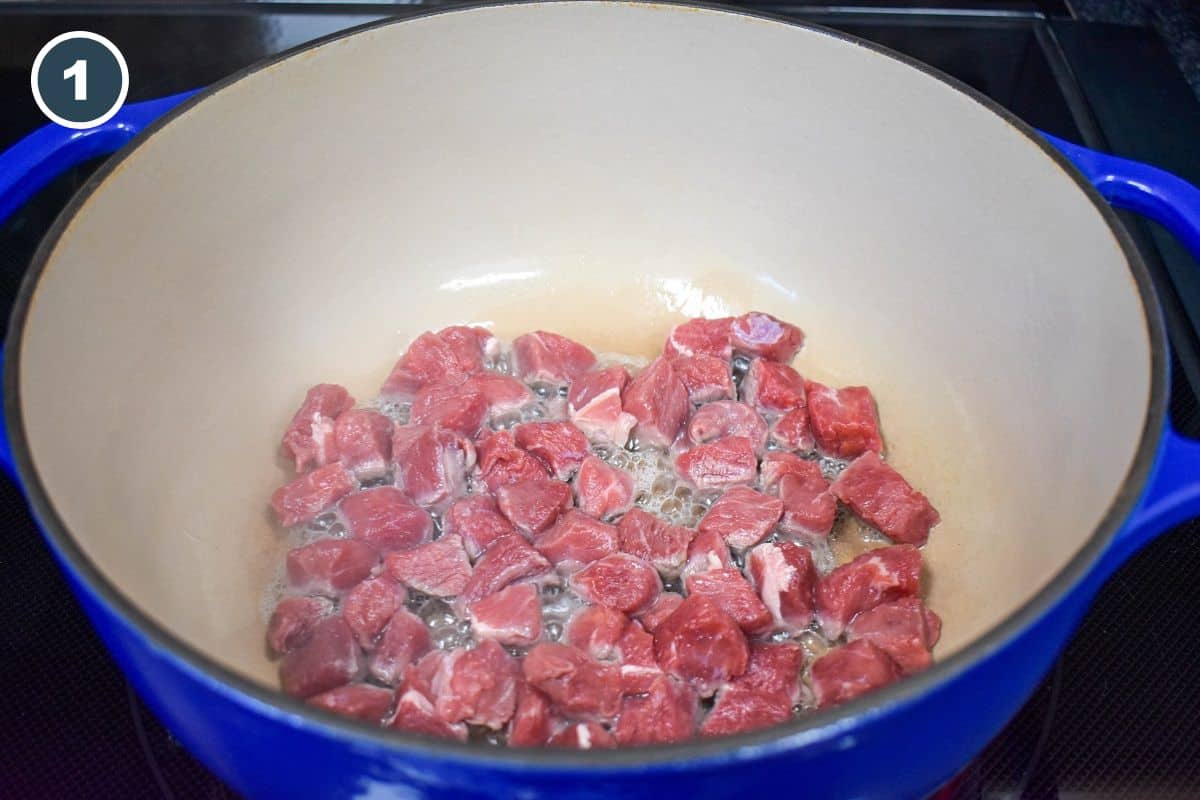 Beef pieces browning in a large pot.