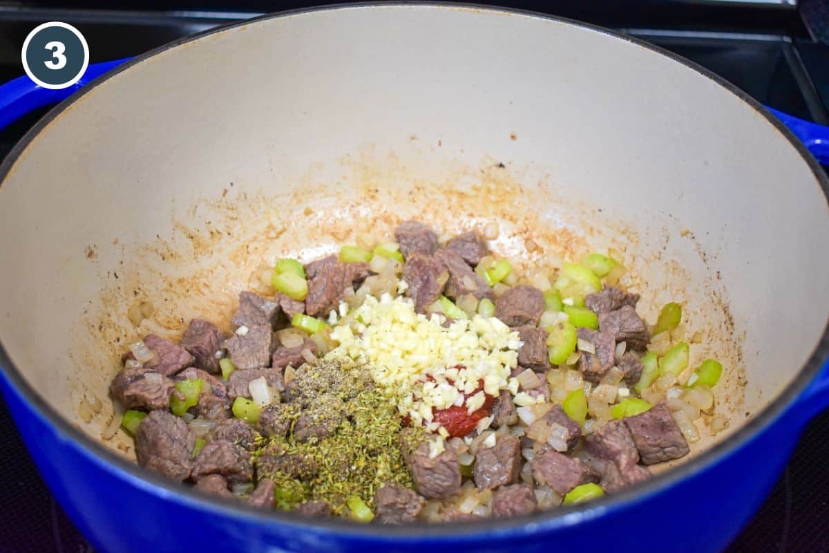 Minced garlic and spices added to the ingredients in the pot.