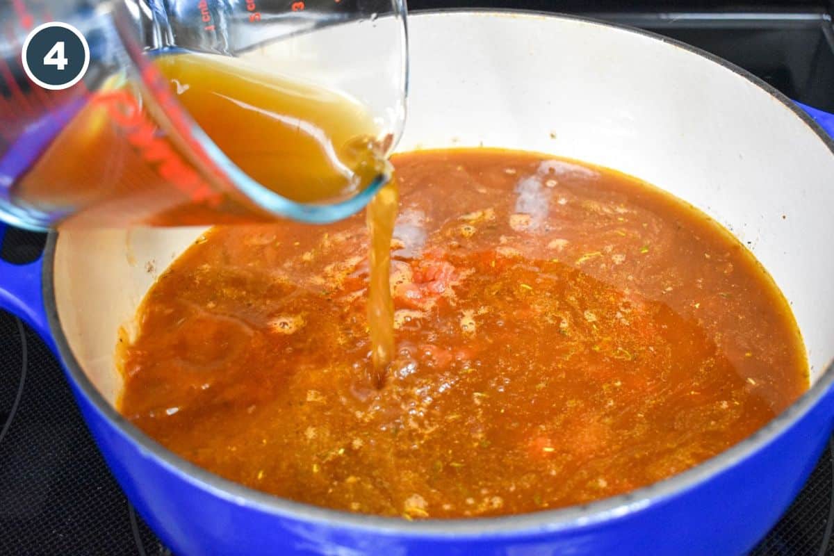 Beef broth being added to the ingredients in the pot.