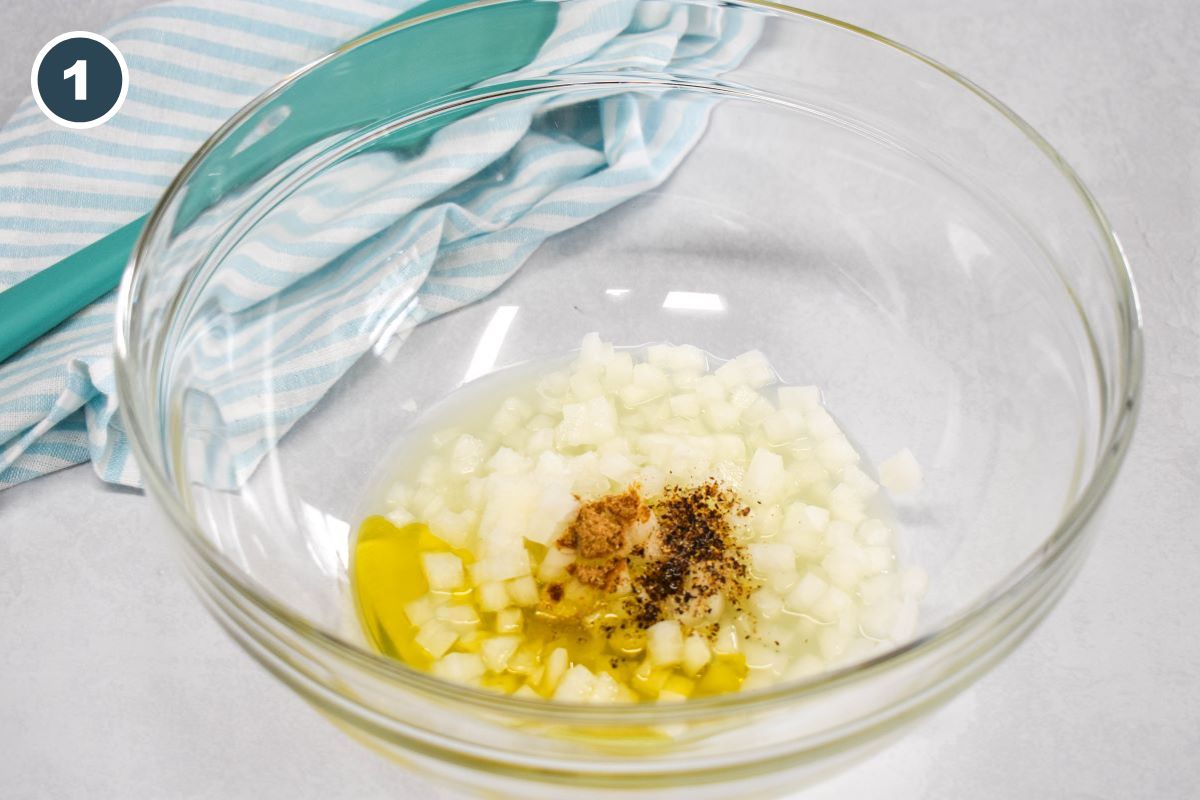 diced onions, olive oil, lemon juice, salt, pepper, and cumin in a large glass bowl.