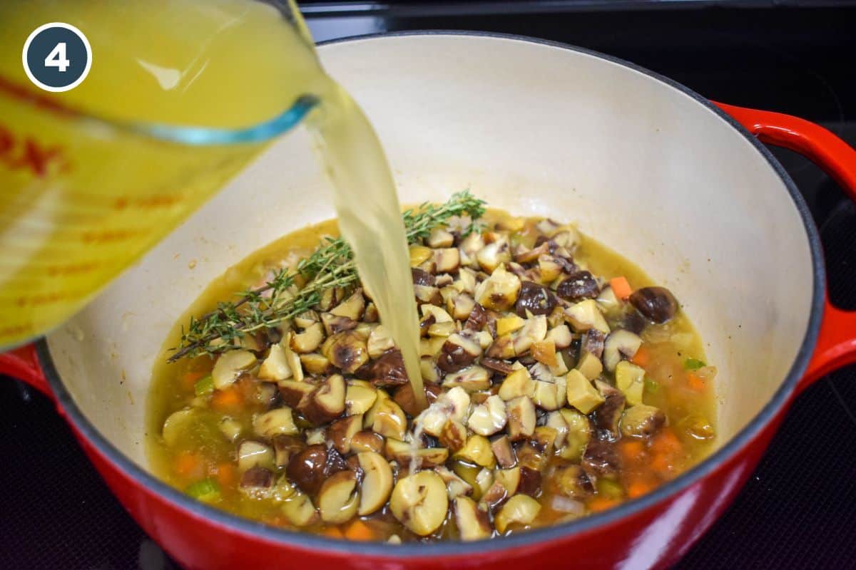 Broth being added to the chestnuts and vegetables in the pot.