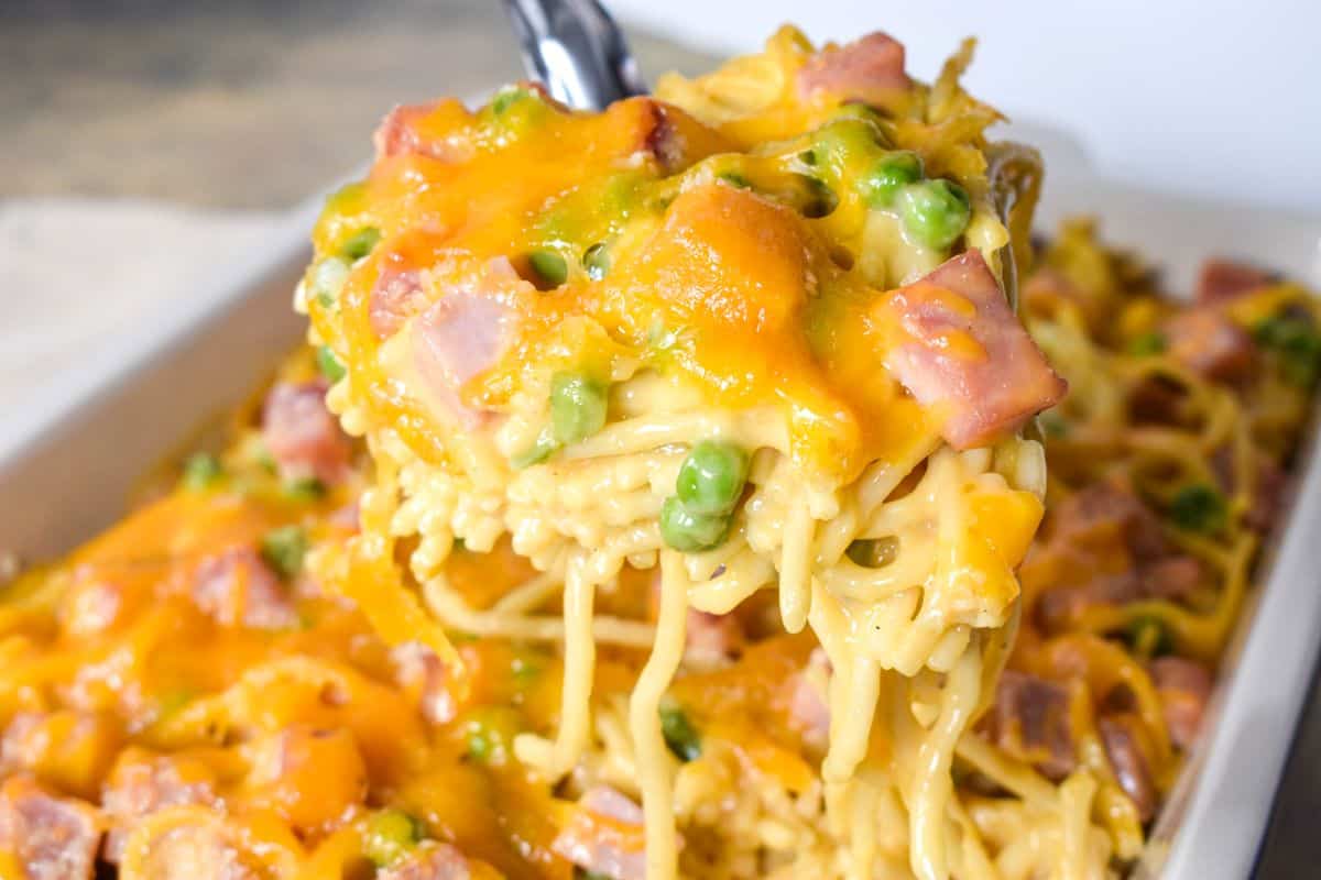 A serving of the pasta being held up with a large serving spoon.