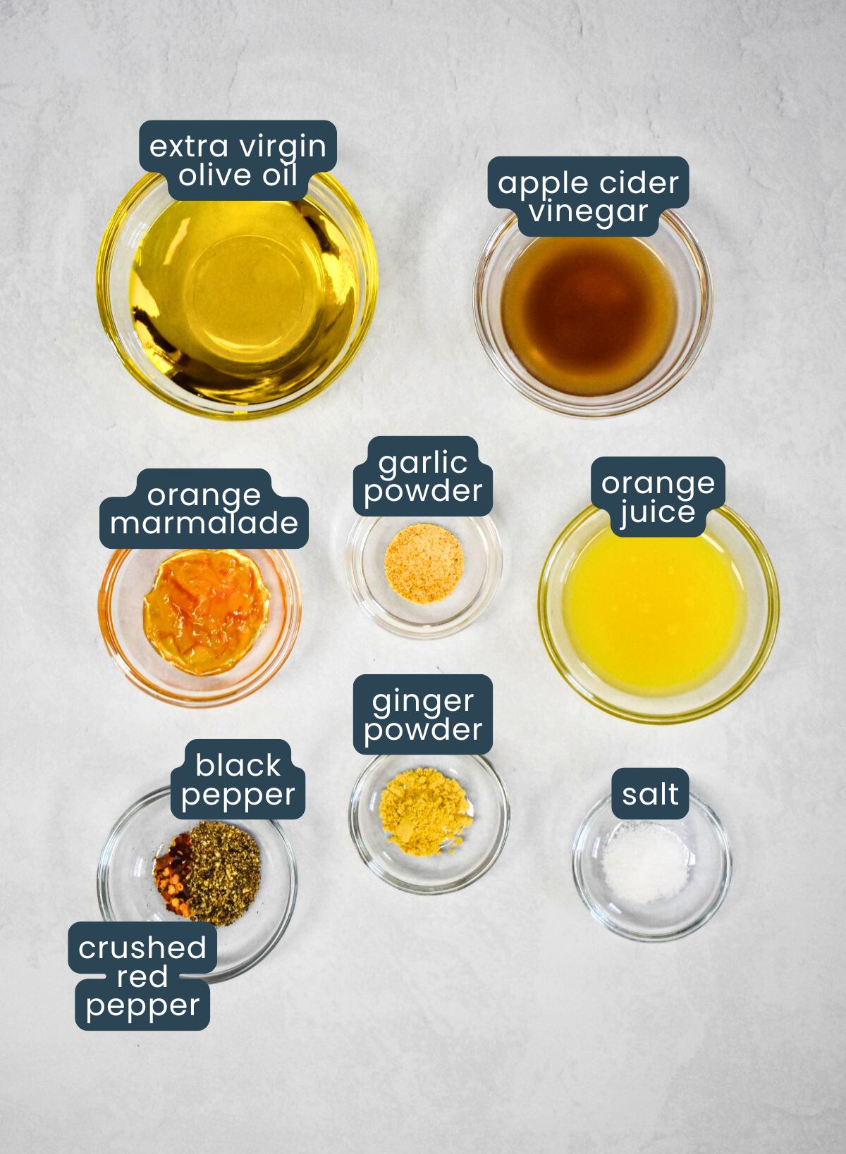 Labeled ingredients for making the dressing, including olive oil, orange juice, vinegar, and seasonings.